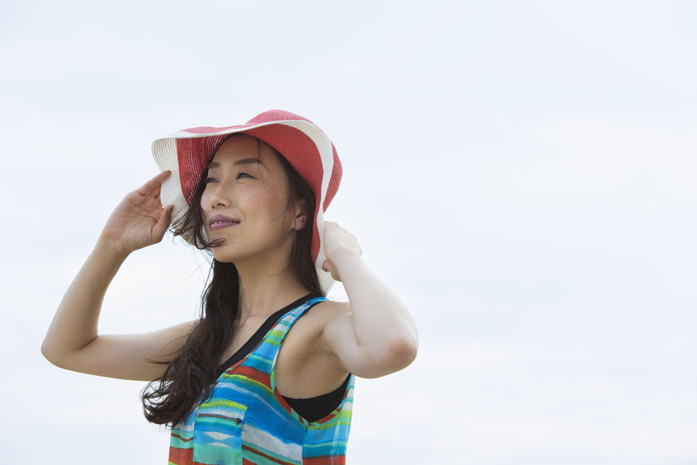 外で紫外線対策をしている女性の写真